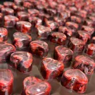 Heart-shaped chocolates with swirling red and white marbling.