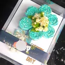Blue Malai Cupcake flower arrangement with jasmine flowers and "Happy Mother's Day" message.