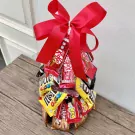 Chocolate Christmas tree arrangement with red bow, made of Kit Kats and M&Ms.