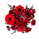 A lush bouquet of red gerbera daisies and carnations with a red satin bow and eucalyptus leaves.