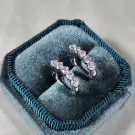 Diamond-studded dangling earrings in a velvet jewelry box.