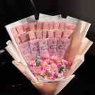 Pink money bouquet with Thai baht banknotes and pink roses, wrapped in light pink paper.