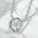 Solitaire moissanite diamond pendant necklace with a white gold chain.