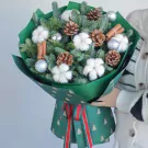 Christmas bouquet with pine, cotton, pine cones, cinnamon sticks, and silver ornaments.