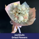 A bouquet of dried flowers in pastel colors, wrapped in pink paper and tied with a ribbon.