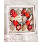 Chocolate-dipped strawberries with gold glitter and red roses in a gift box.
