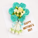 Blue frosted cupcakes arranged as a flower, with real jasmine, malai garland, and "Happy Mother's Day" text.
