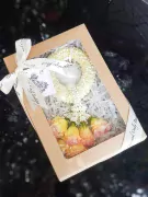 Golden Fresh Malai with yellow and pink flowers in a box.