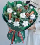 Christmas bouquet with pine, cotton, pine cones, cinnamon, and silver ornaments.