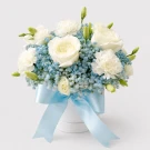 White roses and carnations with blue gypsophila in a white box tied with a blue ribbon.
