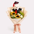 Graduation teddy bear in a bouquet of sunflowers and greenery.