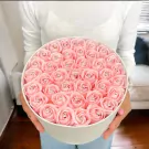 Round white box overflowing with 40 pink artificial roses, each with a diamond accent.