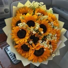 Bouquet of 20 sunflowers and daisies in a car.