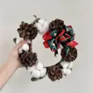 Christmas mistletoe wreath with pine cones, cotton flowers, and festive bows.