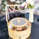 Khao Chae in decorative birdcage-shaped bamboo basket with floral accents.