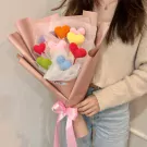 Crocheted heart bouquet in mixed colors, wrapped in pink paper and tied with a pink bow.