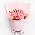 Pink gerbera and carnation bouquet wrapped in pink paper with grey ribbon.