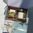 Graduation gift box with candle, matches, and card, tied with a white ribbon.