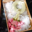 A jasmine and rose garland in a gift box, ready for delivery.