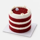 Red velvet cake with cream cheese frosting and daisy decorations on top.
