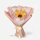 Bouquet with sunflower, baby's breath, and four Minion characters made of flowers, wrapped in pink paper and tied with a yellow ribbon.