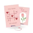 Pink greeting cards with "You Won My Heart" tic-tac-toe and "Love the Way You Are" rose illustration.