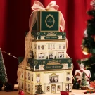 Stacked Christmas chocolate boxes with a manor design, tied with a ribbon.