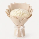 A large bouquet of 100 white roses wrapped in white paper with a hint of pink ribbon.