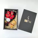 Gift box with red soap roses, teddy bear keychain, and fairy lights.