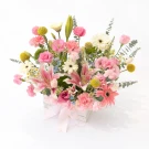 Pink lilies, gerberas, and carnations in a white box with a pink ribbon.