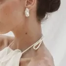 Baroque pearl earrings on a woman's ear, showing off their unique shape and soft luster.