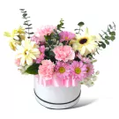 Pink and white flowers with eucalyptus in a white hatbox, adorned with a pink ribbon.