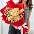 Teddy bear bouquet with white flowers and red wrapping, tied with a white bow.