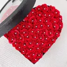 Red heart-shaped box filled with red roses, each with a diamond in the center.