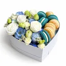 Heart-shaped box with blue and white flowers and macarons.