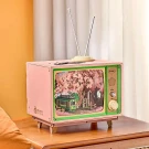 Pink DIY miniature vintage TV plays a cherry blossom scene with a green tram.