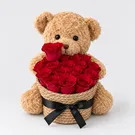 Teddy bear holding a basket of 17 red roses