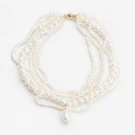 Multi-strand pearl necklace with a baroque drop pendant, on a white background.
