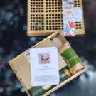 Wooden box with Khao Chae set, featuring a card with food pictures and Thai text.