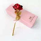 Red and gold artificial rose with a pink ribbon on a pink gift box that reads "24K Golden Rose".