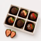 Box of 6 chocolate-covered strawberries, some with sprinkles, some with dried fruit, and one with white nonpareils.