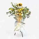 A grand opening floral stand with yellow and white flowers, featuring a black cat logo.