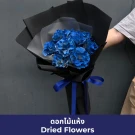Bouquet of vibrant blue dried roses wrapped in black and white paper, tied with a blue ribbon.