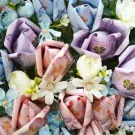 Money bouquet with pink, purple, and blue flowers made from banknotes.