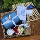 Songkran gift basket: blue scarf, Som Hand inhaler, flower bowls, glass bottle, and cards.