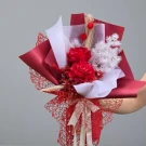 A bouquet of red dried roses and intricate red netting.