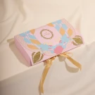 Pink gift box with floral design and gold ribbon, featuring "LE SOURI" logo.