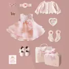 Pink baby gift set with dress, shoes, socks, headband, jacket, and suitcase.