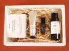 A white gift box filled with YAHN lemongrass & turmeric soap, hand cream, roll-on perfume, and body oil.