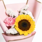 Sunflower with pink carnation and white filler flowers in pink paper.